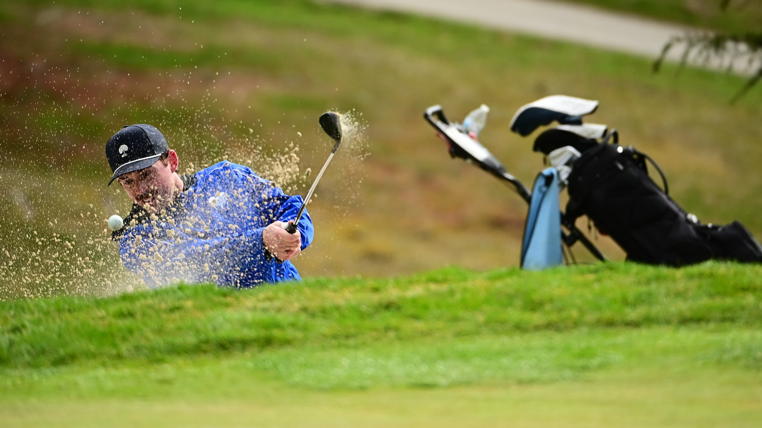 Rob Kozicki hits the ball out of a sand trap.
