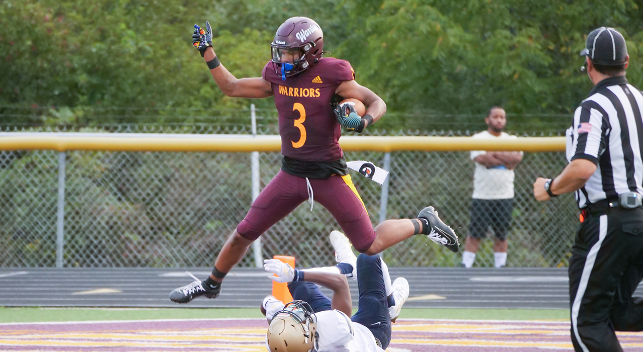 Football player #3 Trey Bell jumping over Canisius defender
