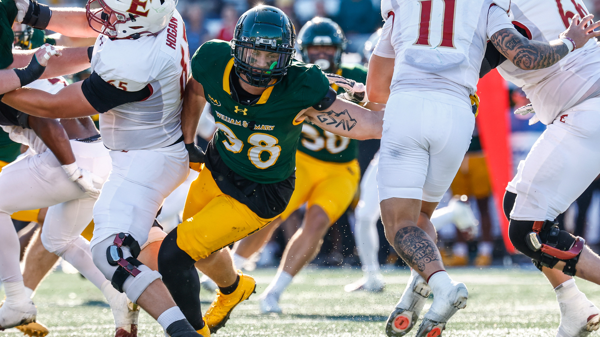 W&M defensive lineman Just Krueger rushes past Elon blockers to make a tackle at Zable Stadium