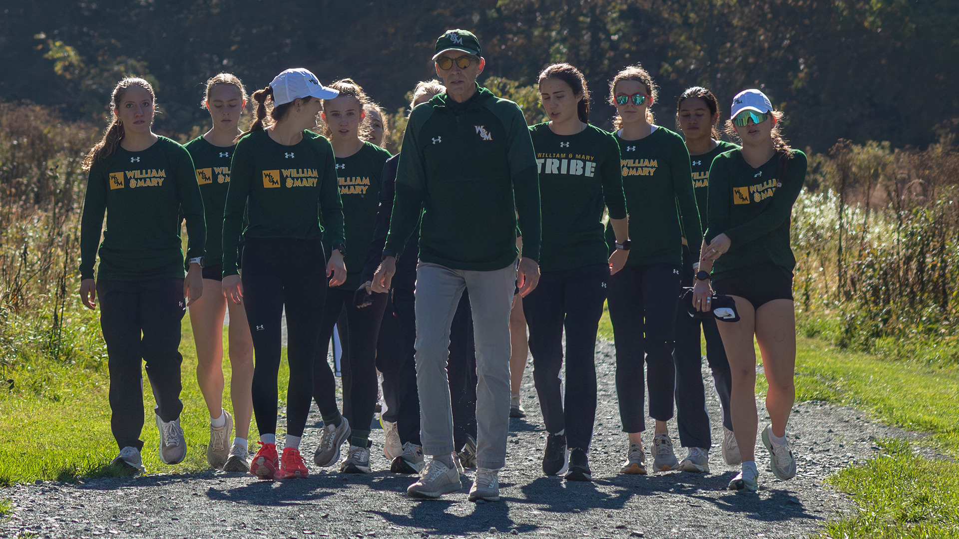 Lead by coach Scott Jones, the Tribe women's cross country team walk up the gravel path at the Firetower Project Run in Boone, N.C., before the race. 