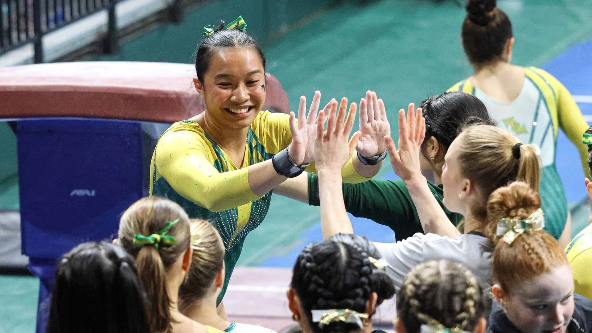 Addison Pabellon celebrates with teammates during a meet at Kaplan Arena