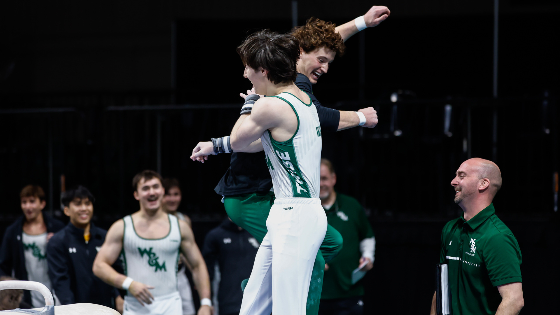Members of the W&M gymnastics team celebrate during a meet at Kaplan Arena