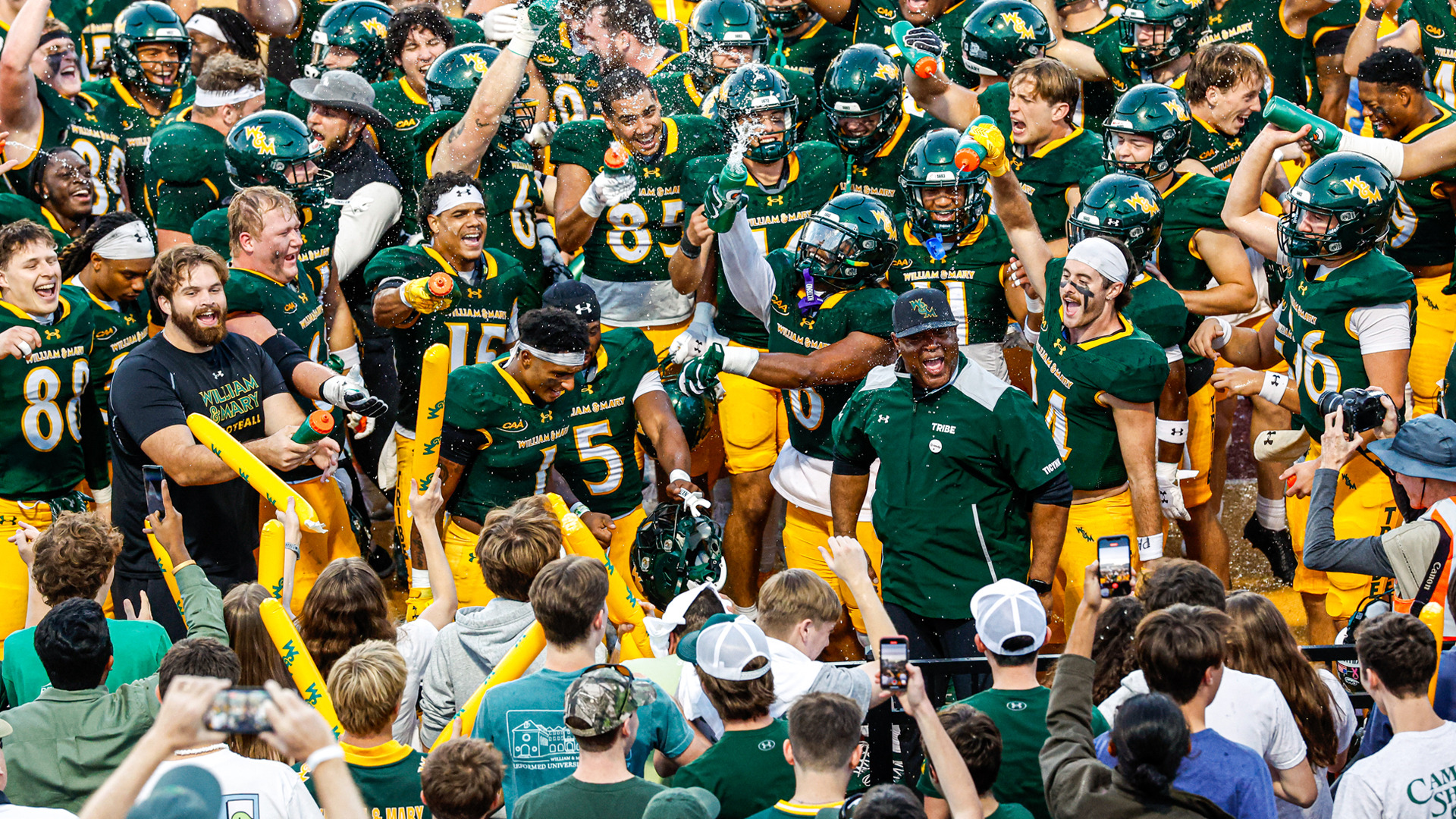Members of the William & Mary football team celebrate near the sidelines with fans at Zable Stadium following a win against Elon.