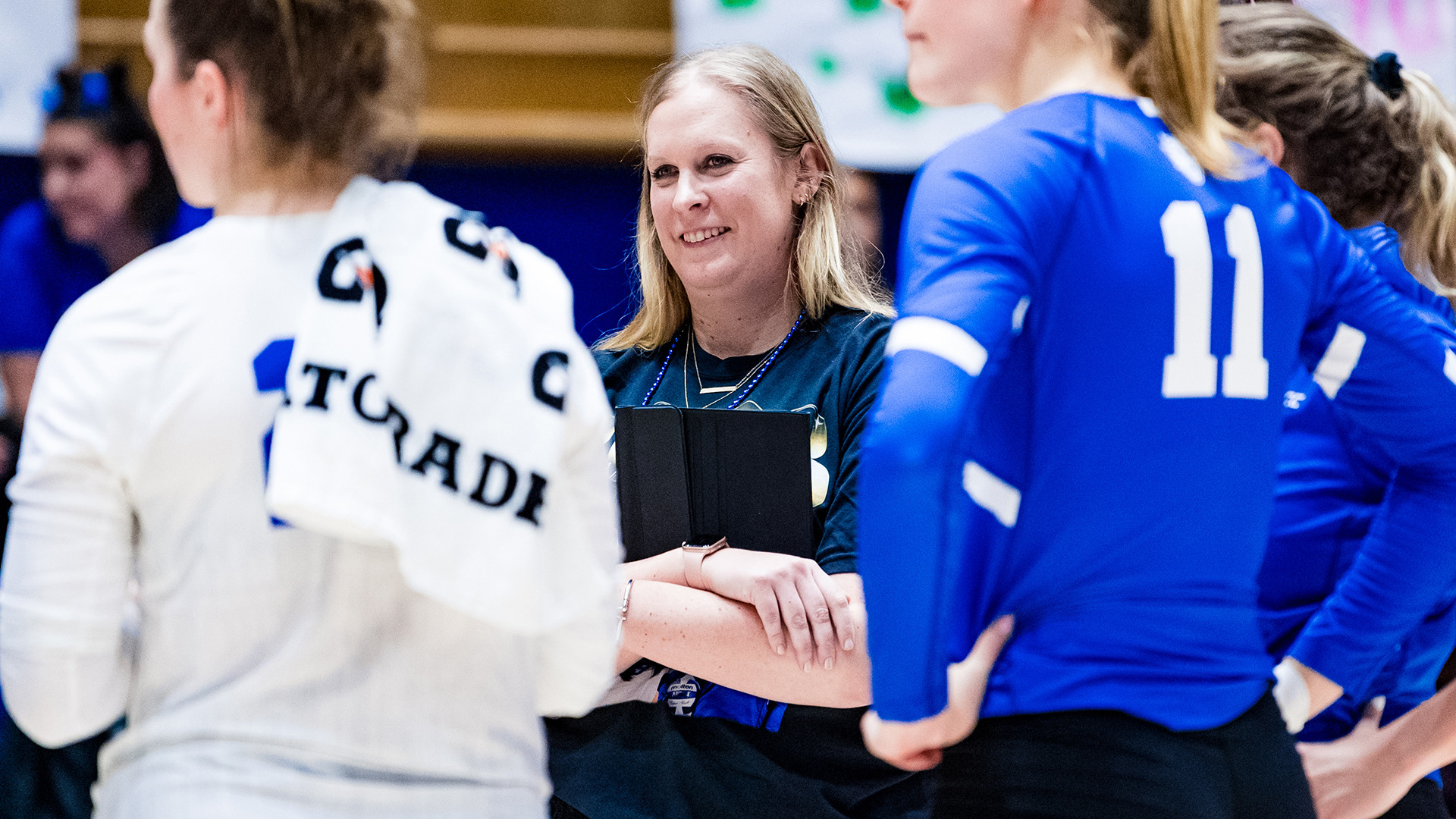 Kellie Catanach Johnson, who was named the W&M head volleyball coach, smiles looking at the court in a match for Duke vs. Clemson. 