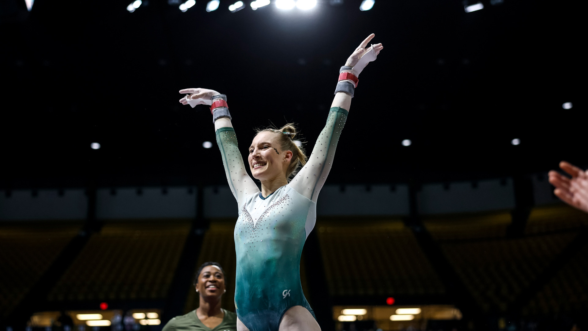 Caroline Blatchford celebrates a successful bars routine at Kaplan Arena