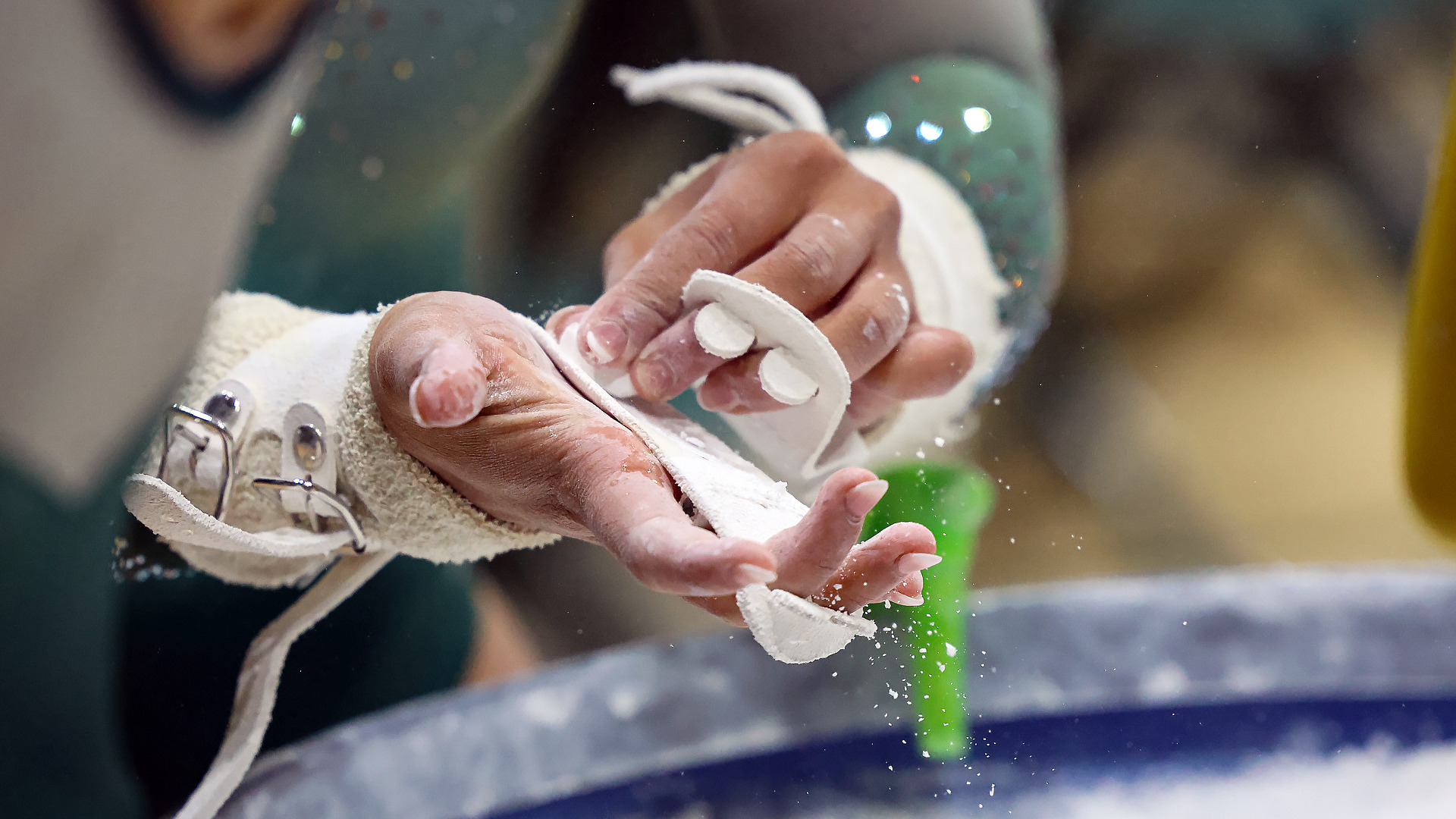 W&M women's gymnast chalks grips