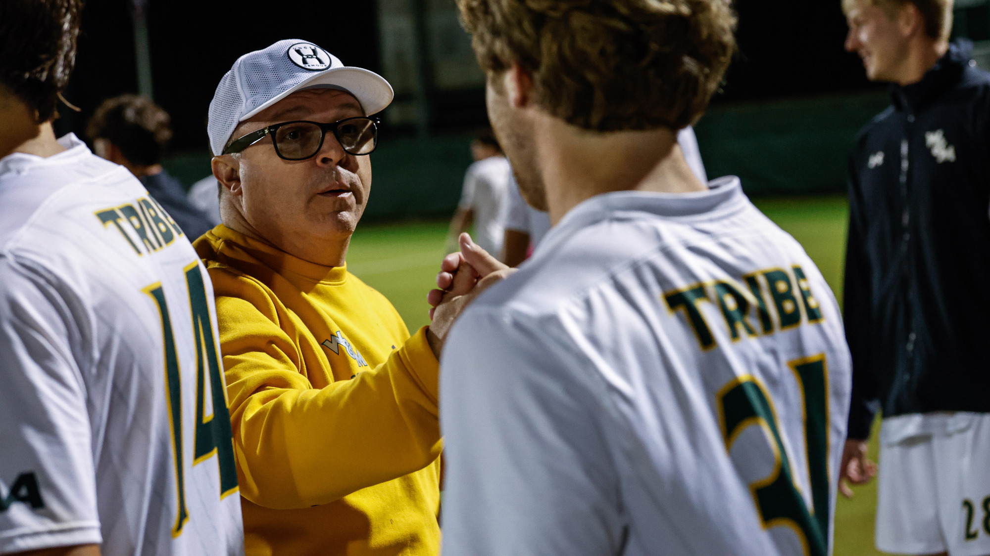 Head coach Chris Norris slaps hands with a Tribe players during the introduction of starting lineup in W&M's home game vs. UNCW. 