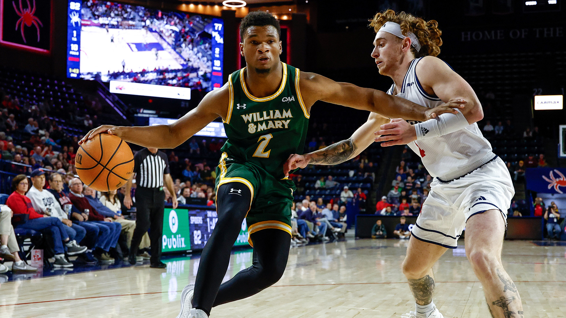 Chase Lowe dribbles to the baseline with his arm extended and a Richmond defender on his side. 
