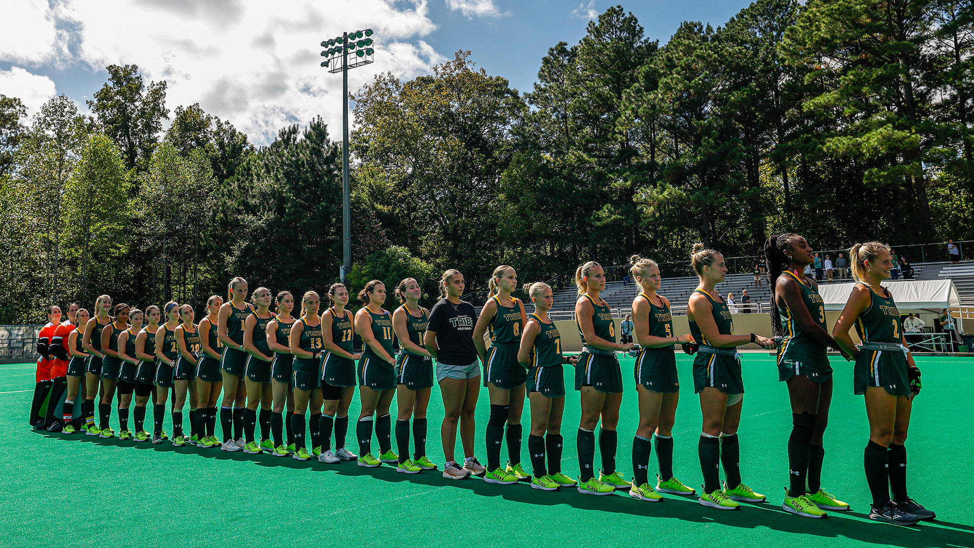 Tribe field hockey stands hand and hand during the national anthem prior to a match with Monmouth. 