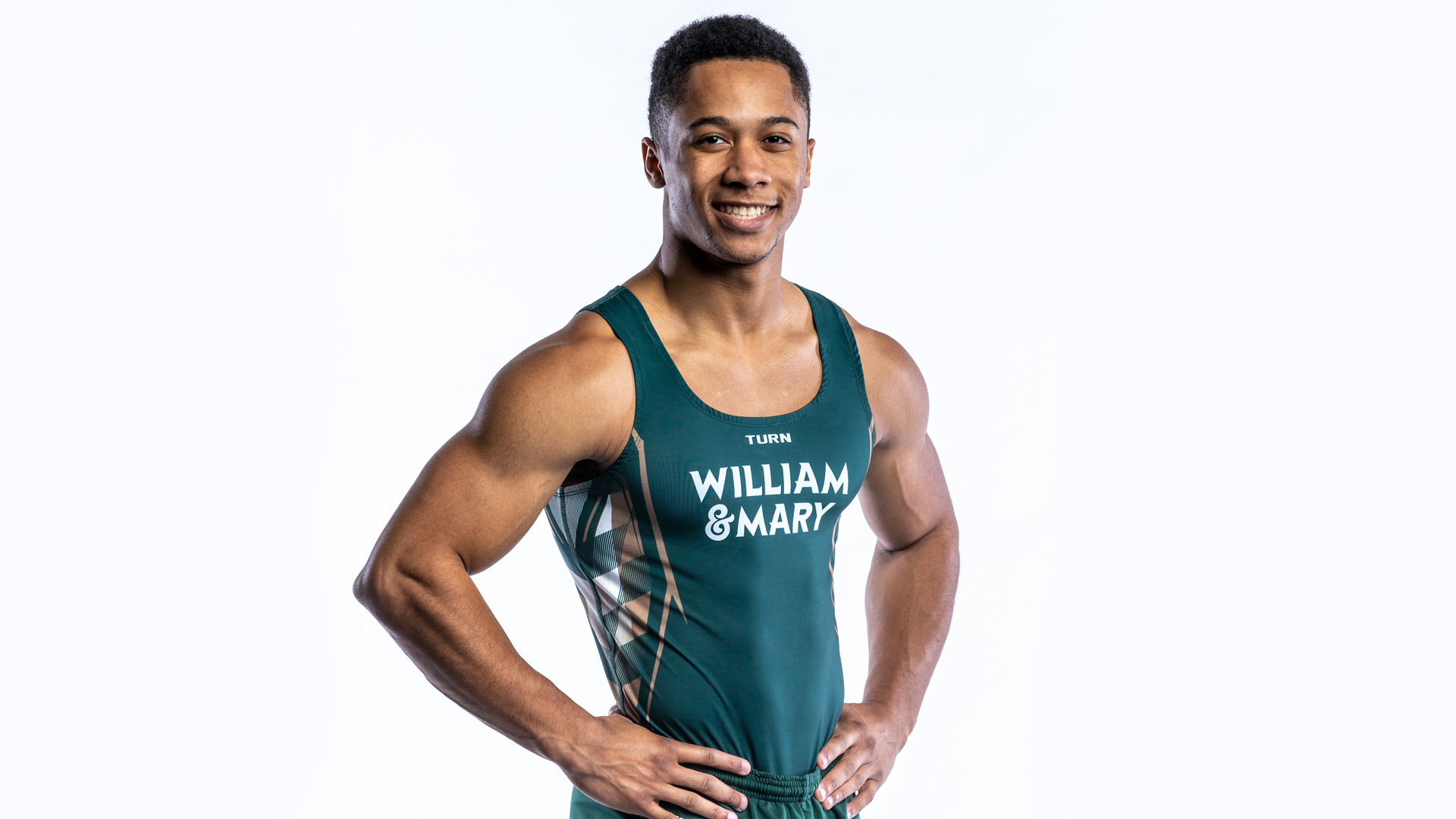 Christian Marsh stands with his hands on his waist in front of a white backdrop