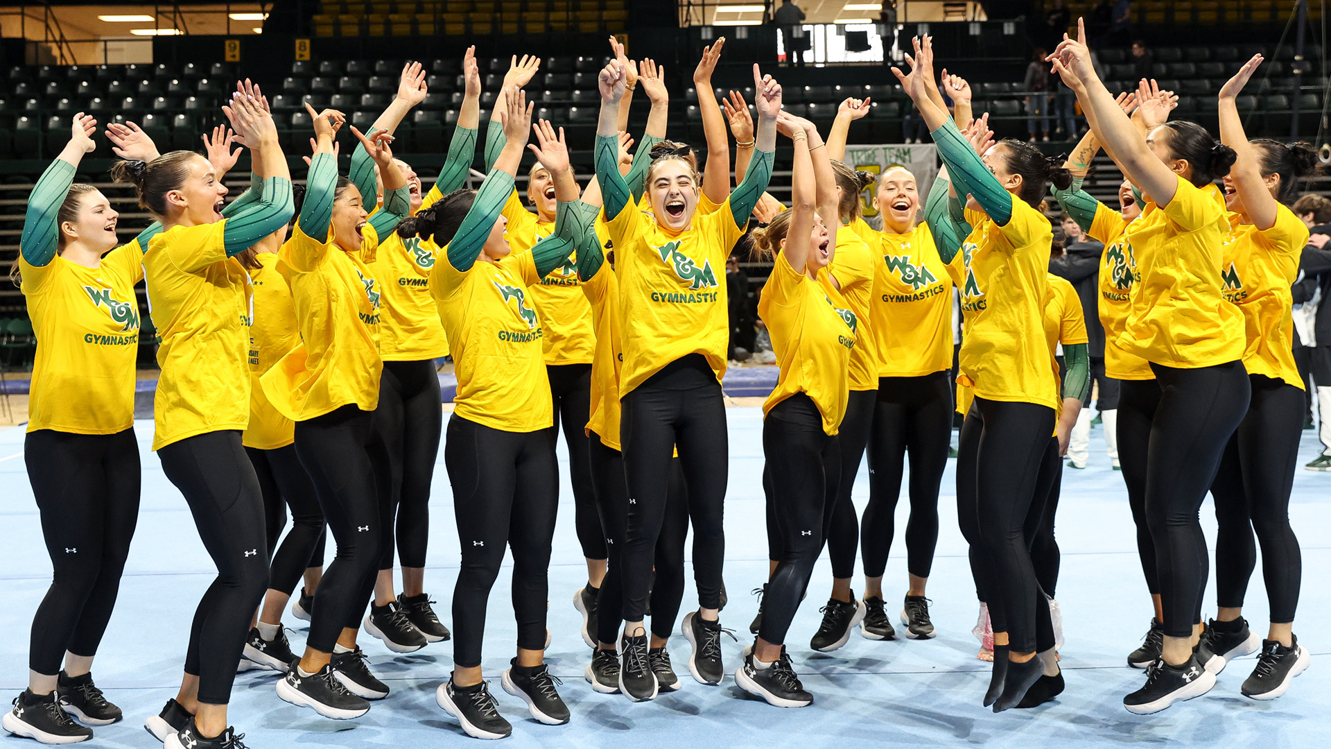 Members of the W&M women's gymnastics team celebrate after defeating Alaska at Kaplan Arena