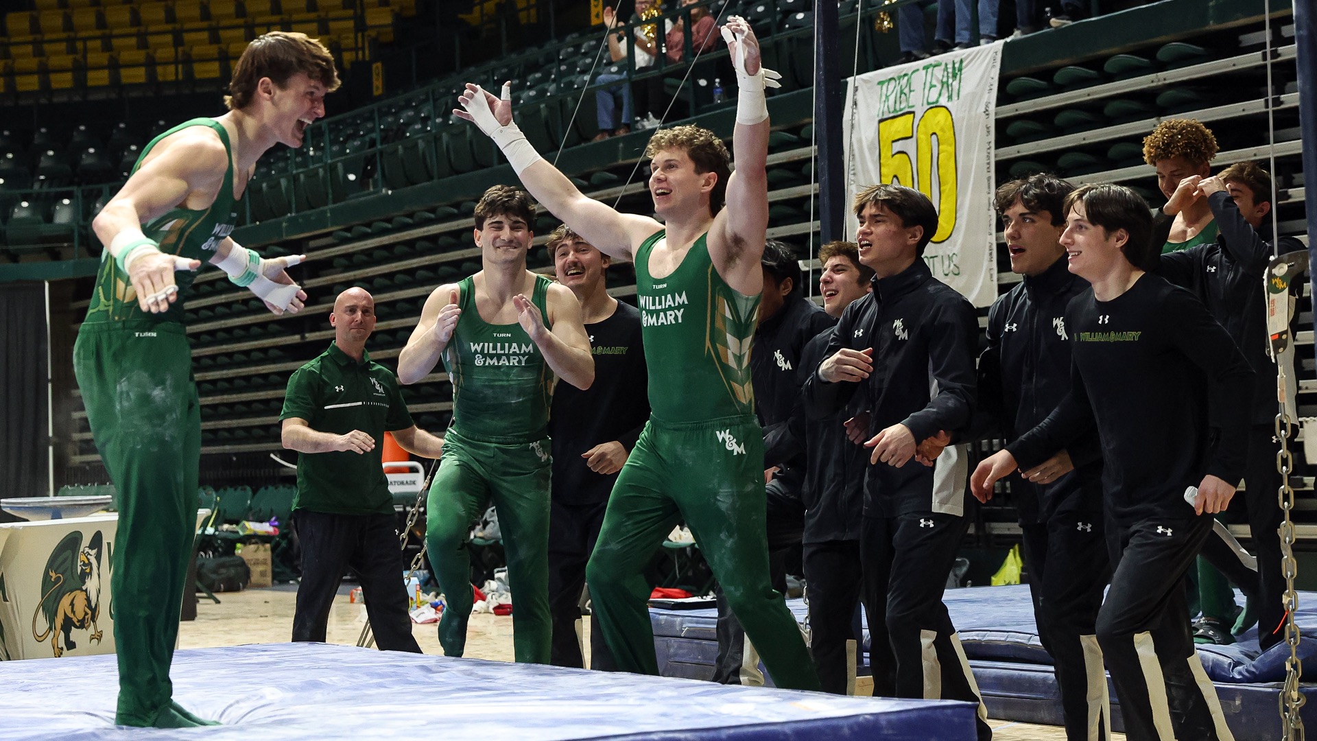 Members of the W&M men's gymnastics team celebrate a successful routine during a meet at Kaplan Arena