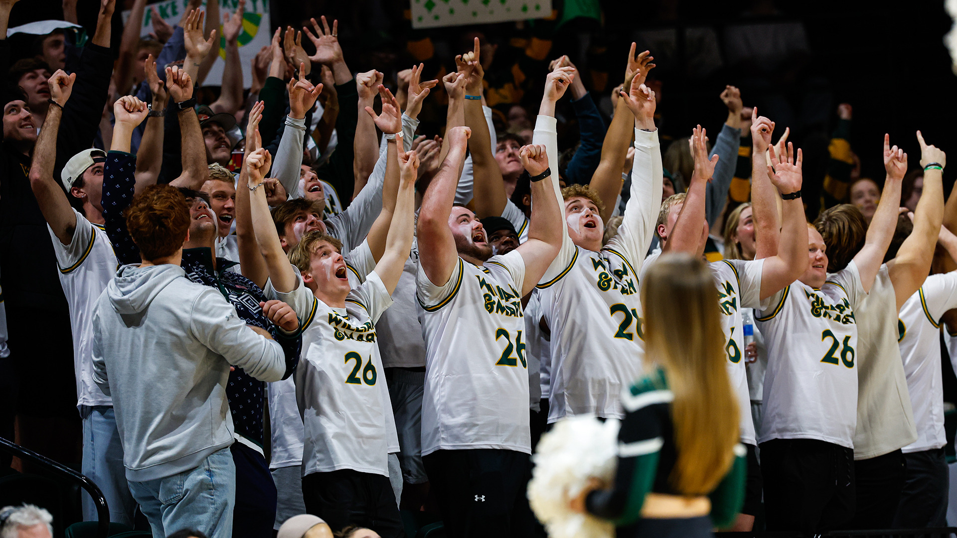The Tribe student section celebrates with their arms raised in the air wearing the white promotional jerseys during W&M's home game vs. UNCW on Jan. 22, 2026. 