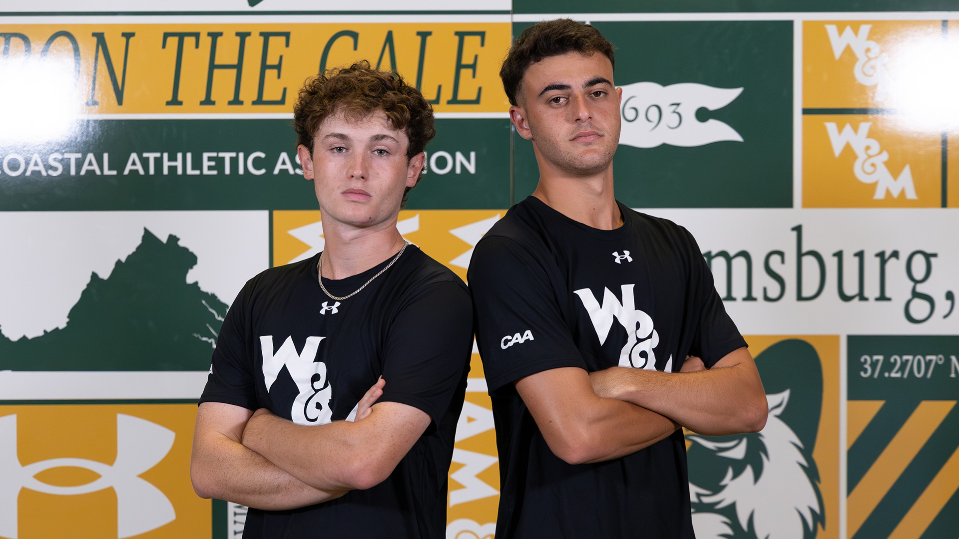 Oliver Hague (left) and Gur Trakhtenberg stand back to back with their arms crossed against the scrapbook backdrop during media day. 