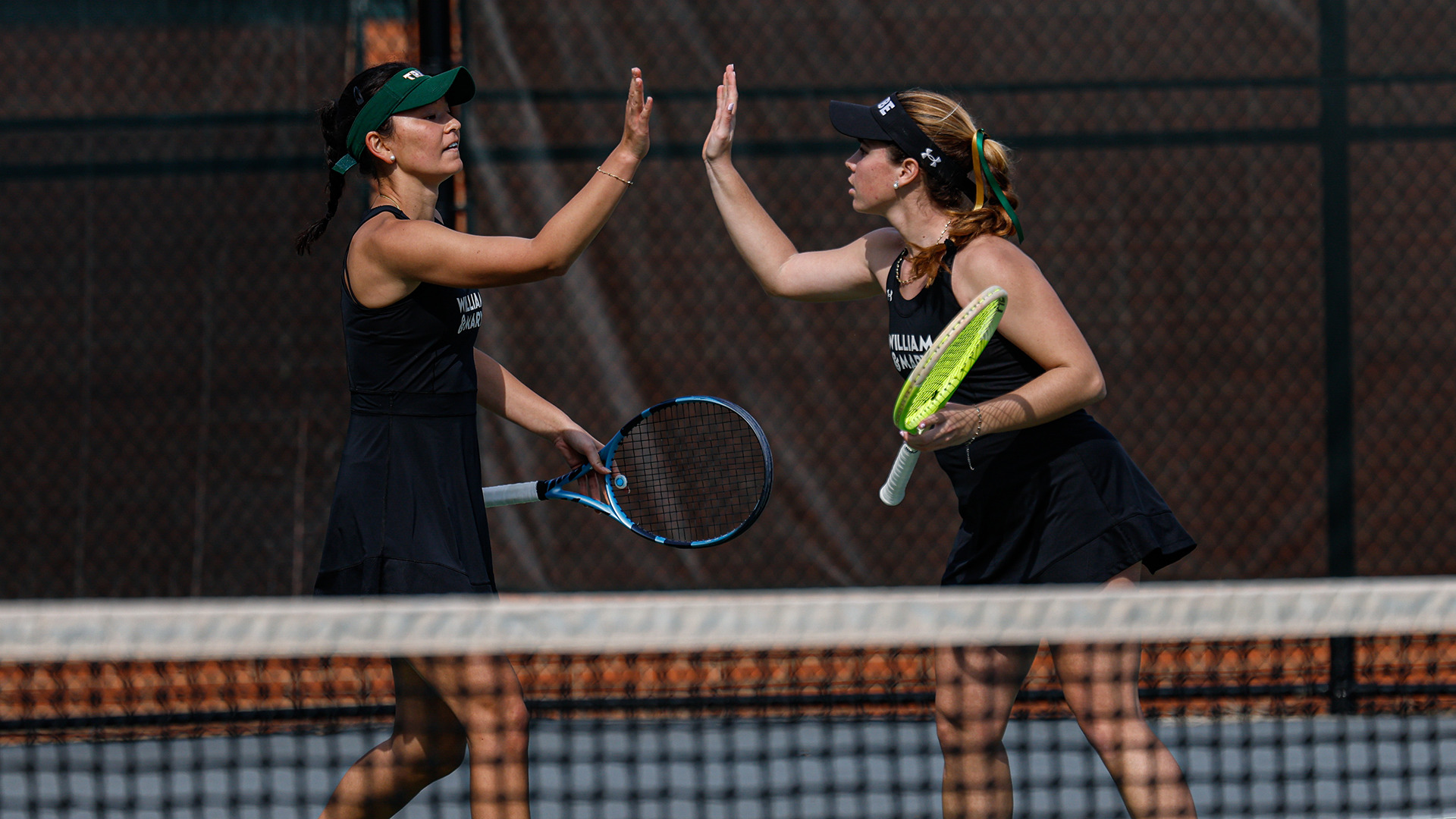 Mira Kernagis and Alexia Gonzalez-Galino after winning a point during doubles when the Tribe hosted James Madison at the Mackesey Tennis Center. 