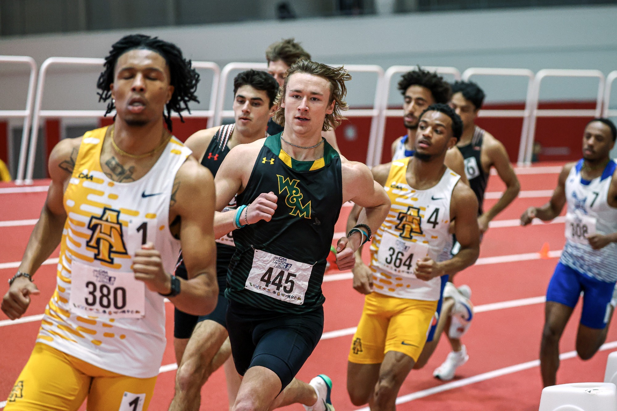 Jonathan Kumer runs in a pack around a curve at the 2026 CAA Indoor Track & Field Championships in Boston. 