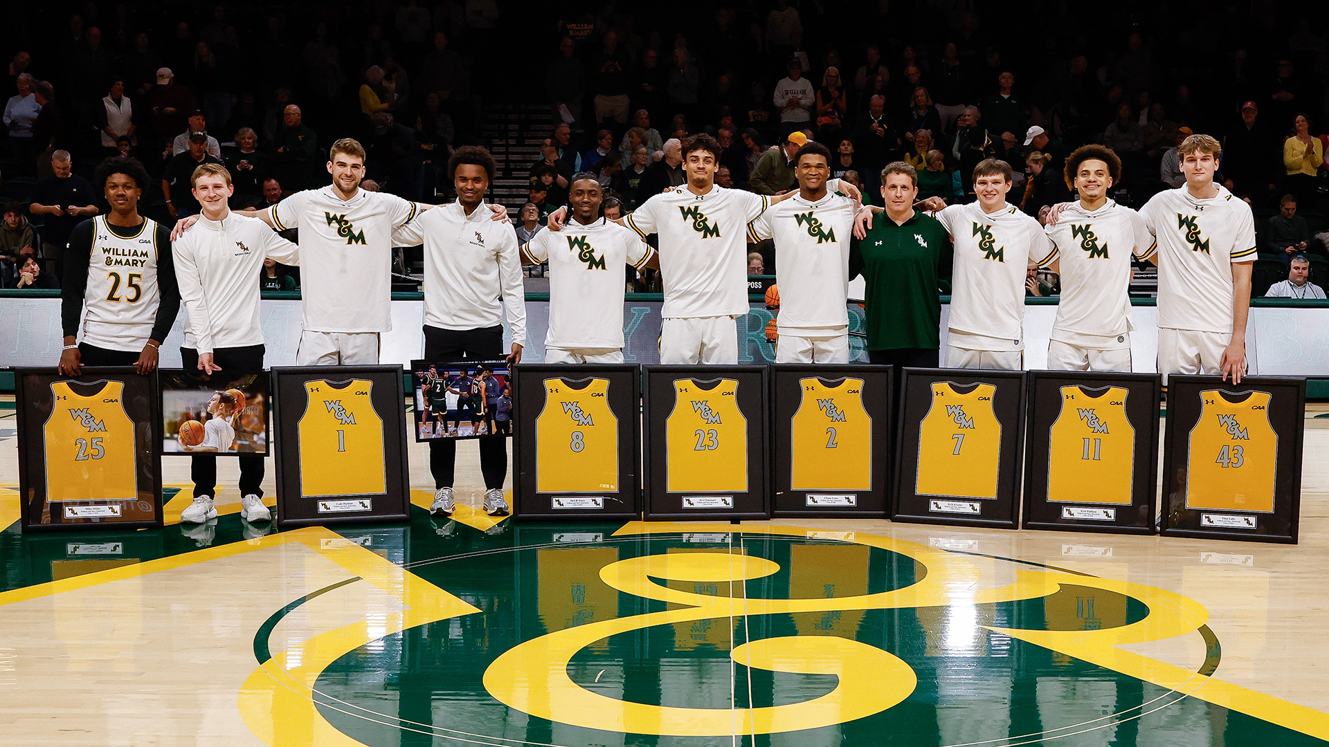 The Tribe's senior class stands with their uniforms framed in jerseys with head coach Brian Earl at half court. 