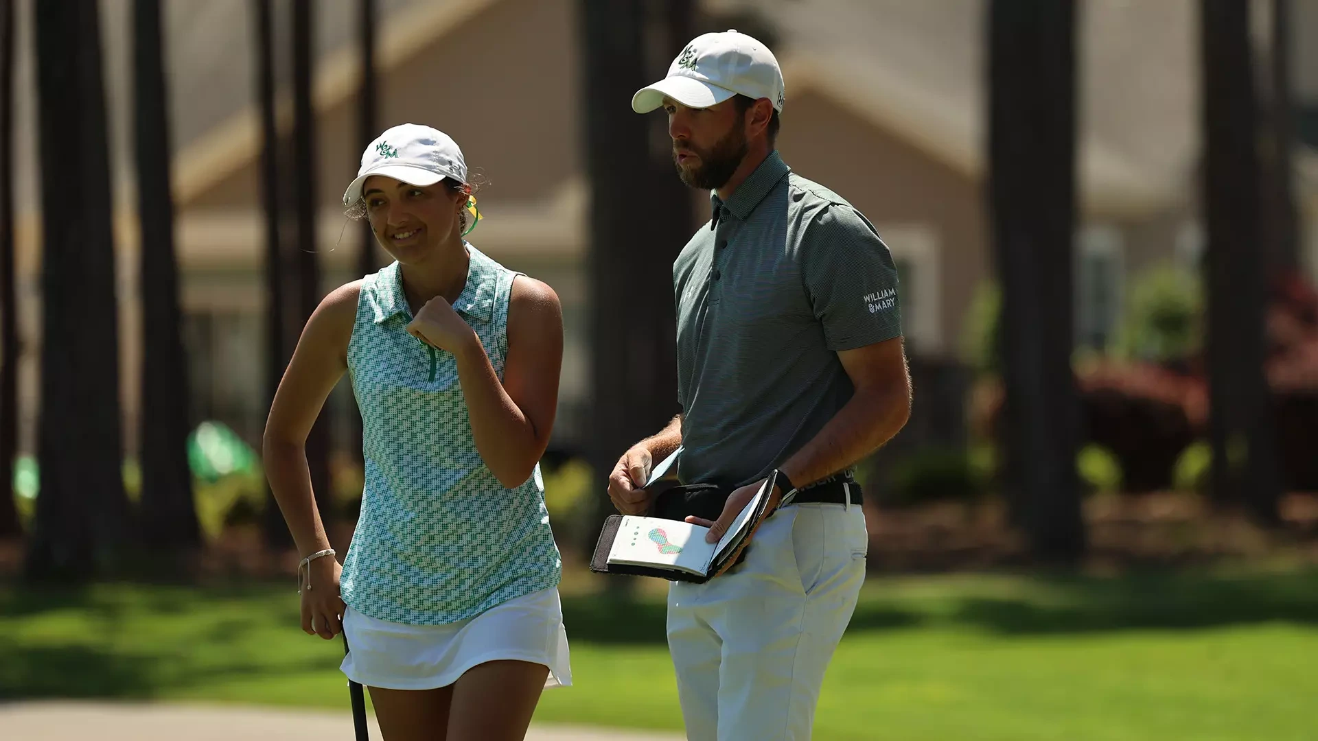 Jennifer Osborne smiles as she walks away from head women's golf coach Jonathan Howard following a conversation greenside during the second round of the CAA Championships at the Reserve Club at St. James. 