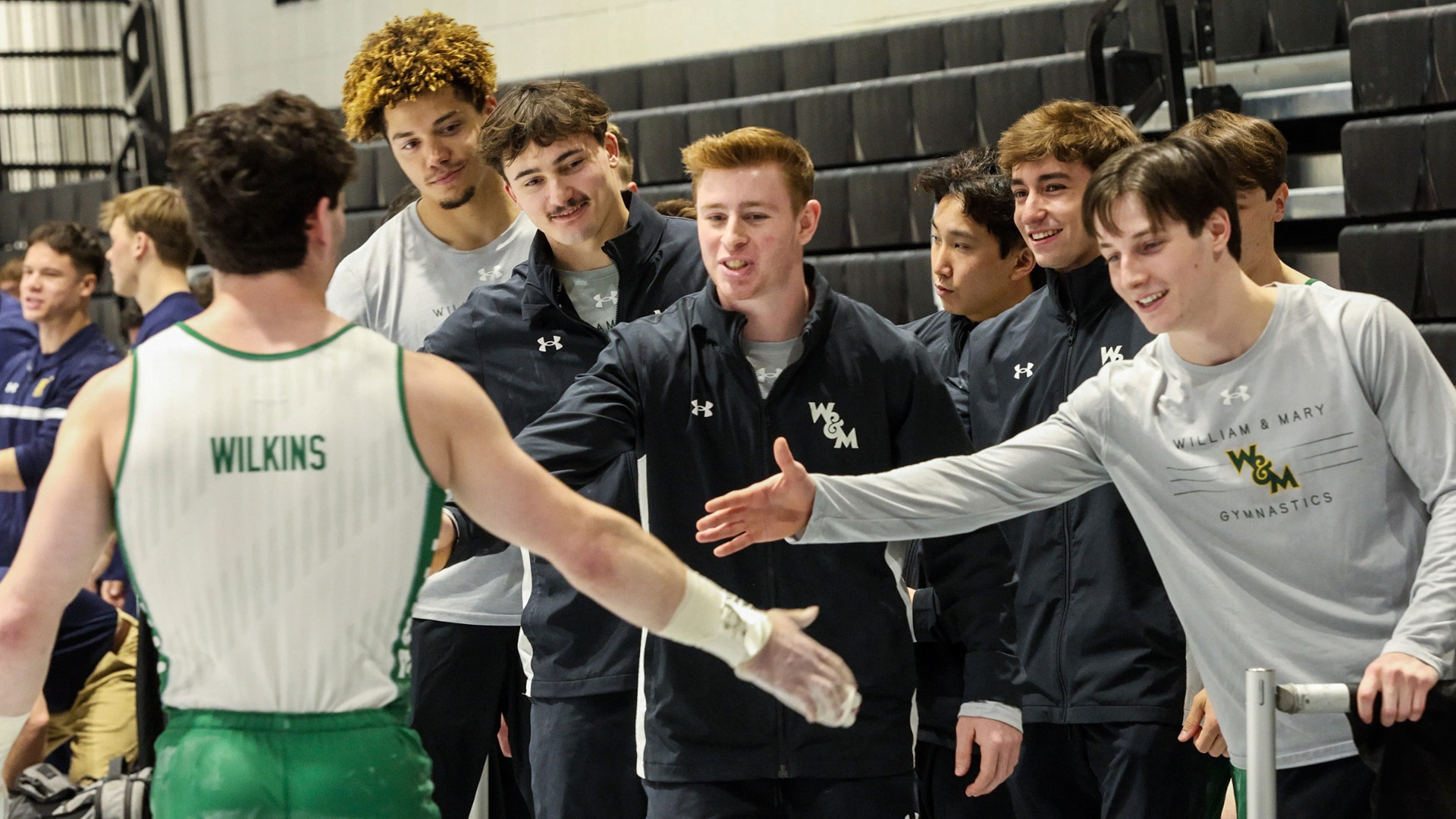 Evan Wilkins celebrates with teammates following a routine at the ECAC Championship