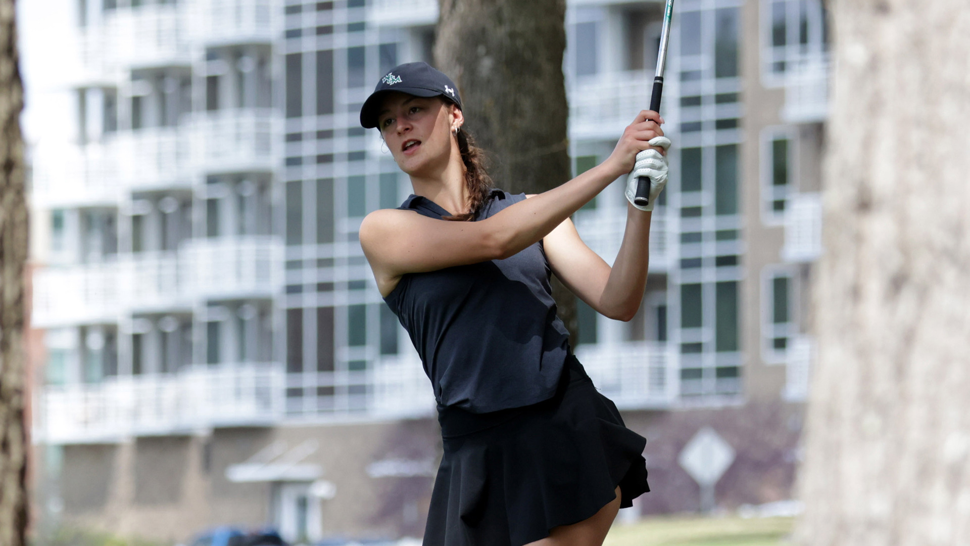 Reagan Garnsey follows through and poses with an iron between the trees during a practice round at the Carolina Challenge Cup. 