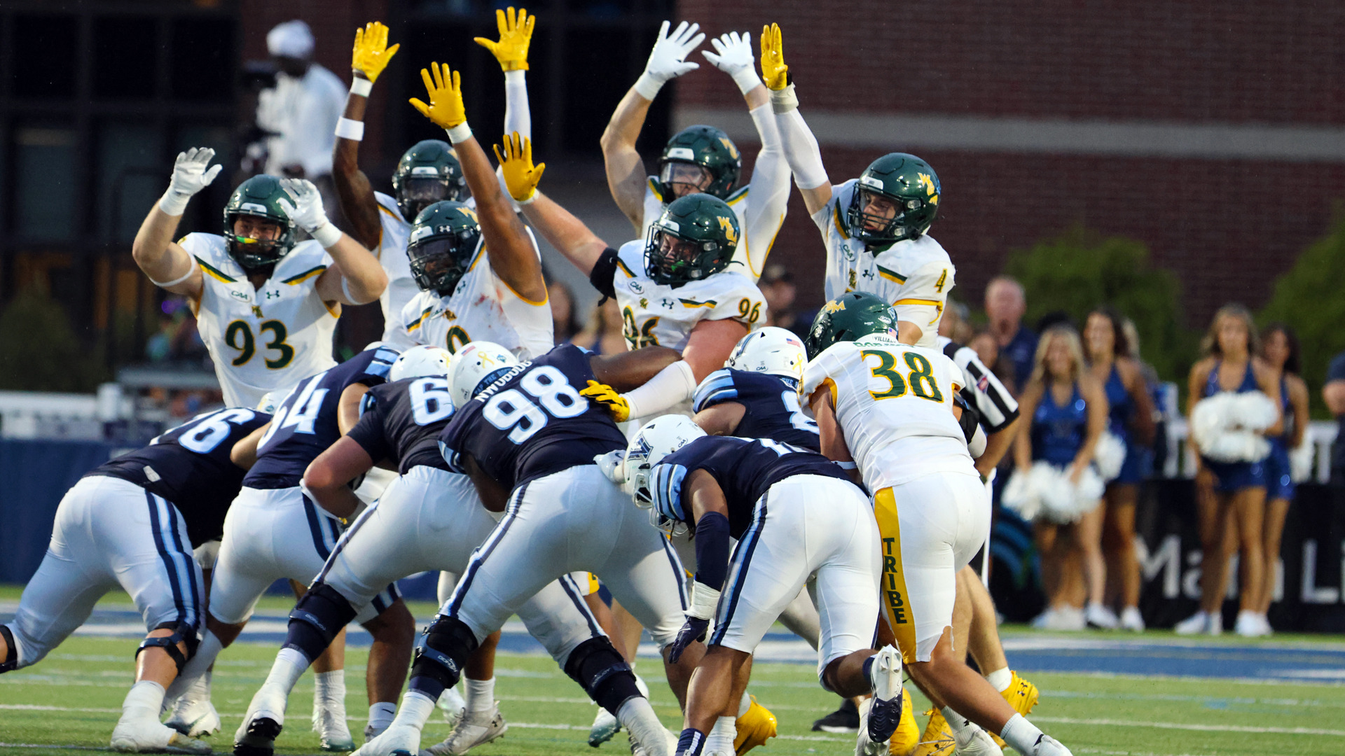 A group of W&M football players leap into the air attempting to block a field goal attempt by Villanova