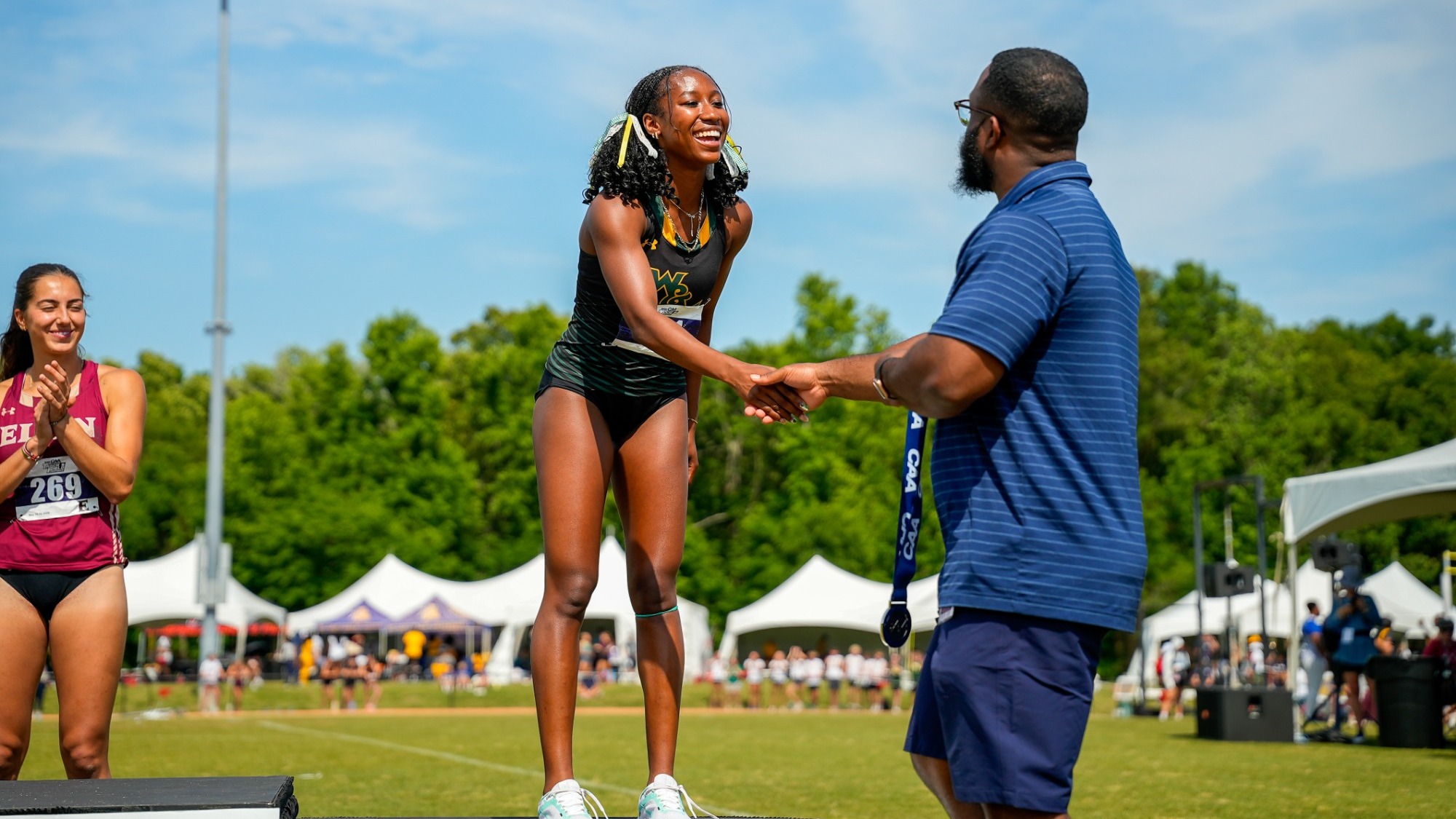 Kennedy Reynolds receiving a silver medal at the CAA Championships