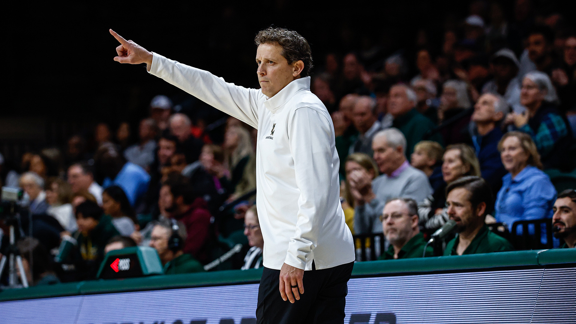 Head coach Brian Earl points down court from the sidelines durng the Tribe's home win over Old Dominion in 2025. 
