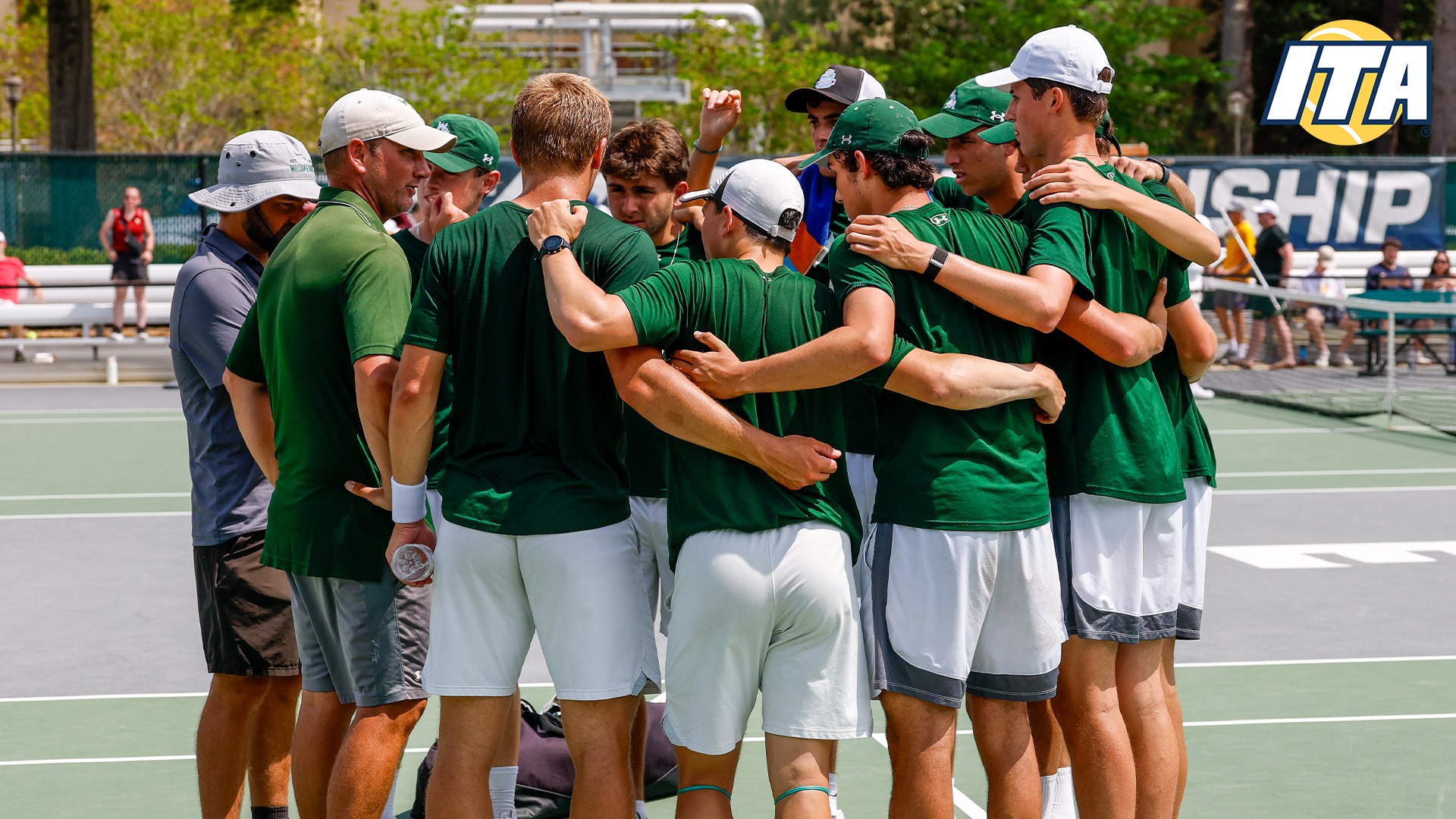 William & Mary men's tennis huddled up on the tennis court with the ITA logo in the top right