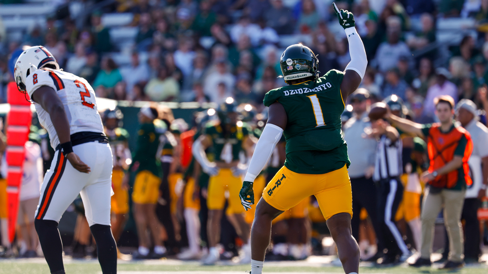 Davin Dzidzienyo celebrates by holding his hand in the air during a game versus Campbell at Zable Stadium