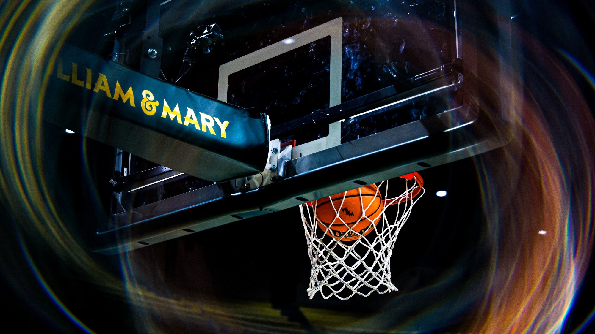 Basketball pageantry of a basketball scoring in a basketball hoop