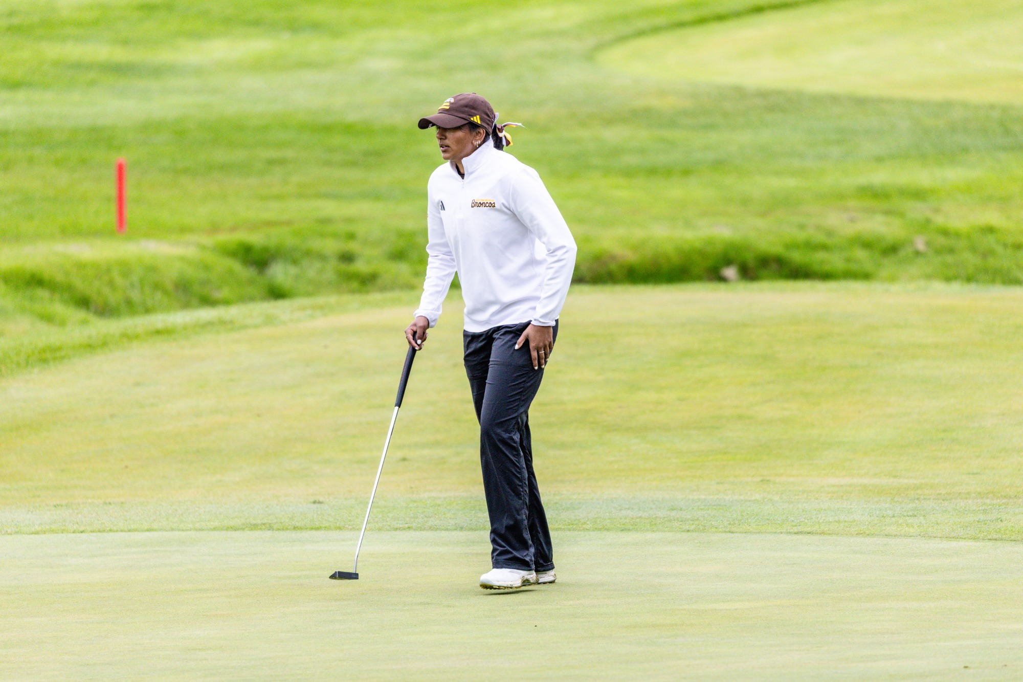 A Western Michigan golfer walks across a green at the Firestone Country Club Fazio Course