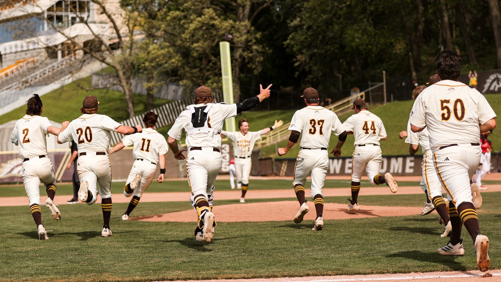 Drew Howard waits with open arms to celebrate his Senior Day walk-off single with his teammates