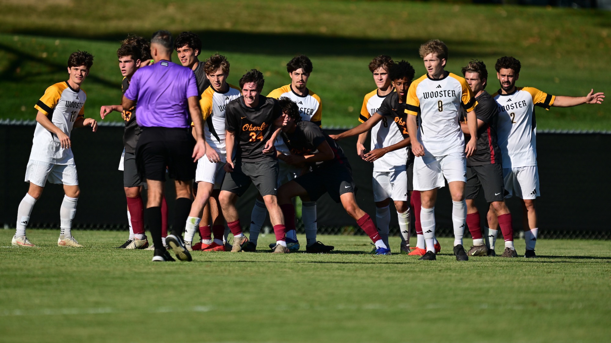 The men's soccer team lines up ready to defend a free kick