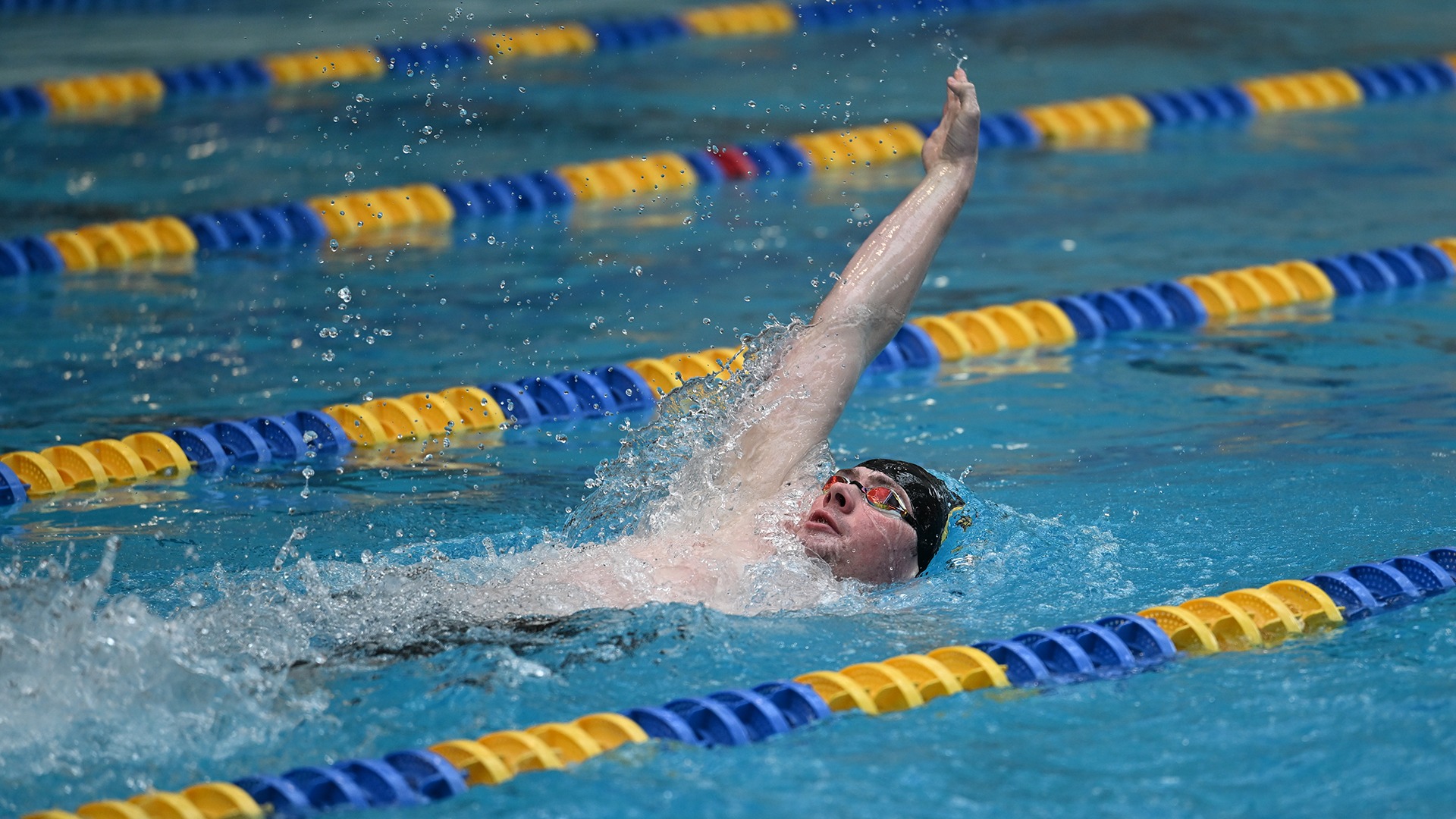 action photo of Ryan Stokes swimming the backstroke at the 2025 Wooster Invitational
