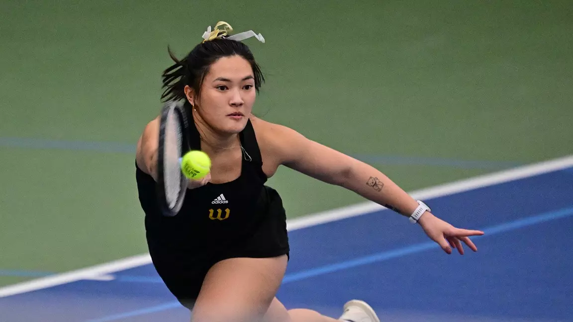 Hernishin lunges for a ball indoors