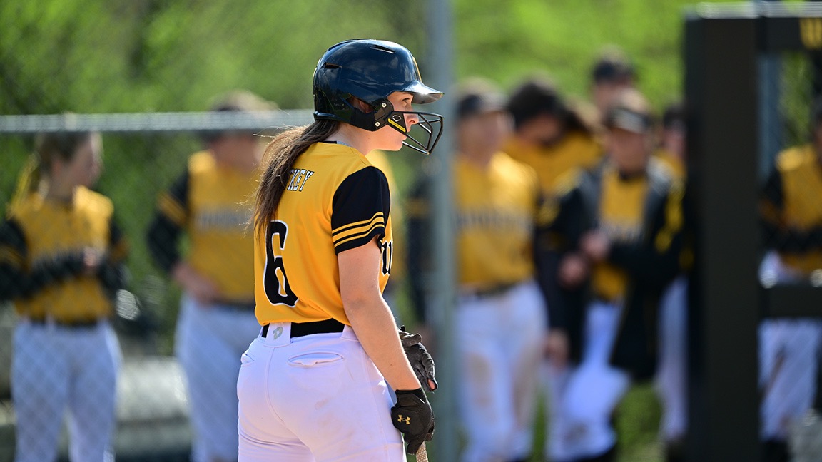 Emma Hetkey holds a bat with the back to the camera