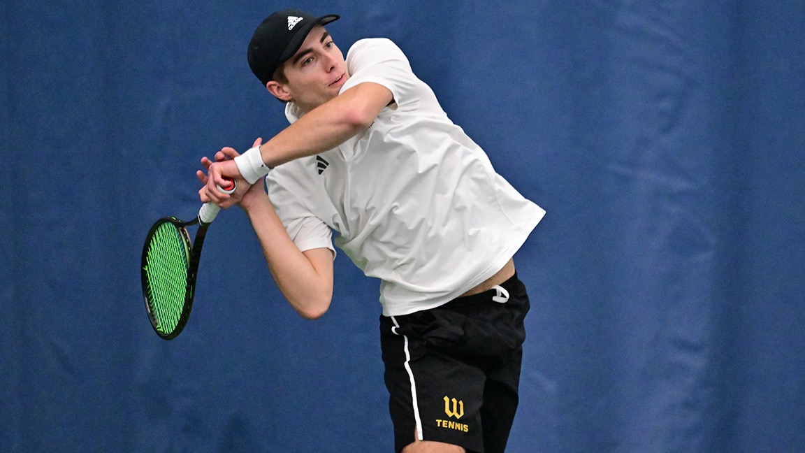Andrew Wissman hits a return in an indoor match