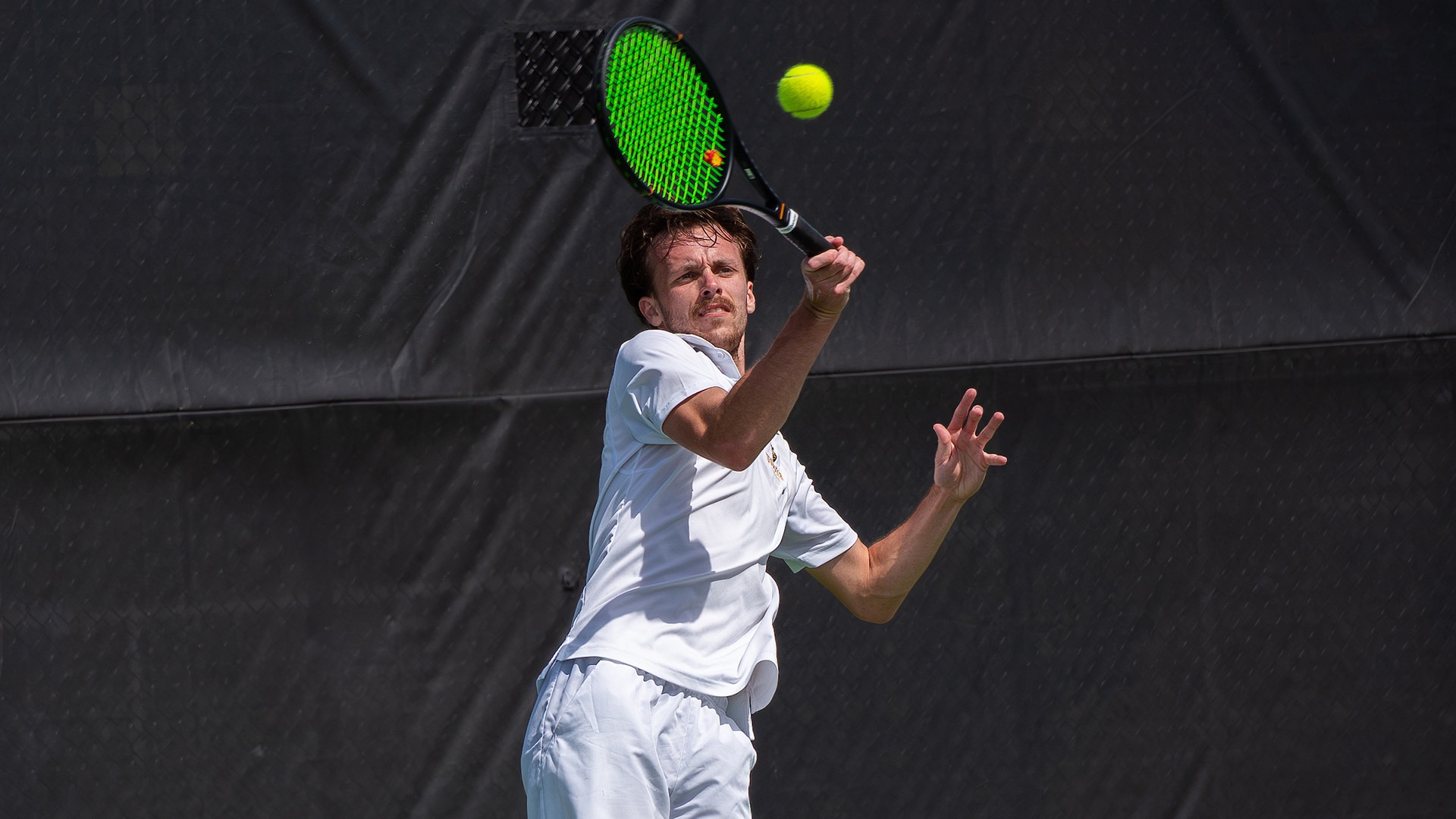 Anthony VanOyen 26 returns a serve outdoors
