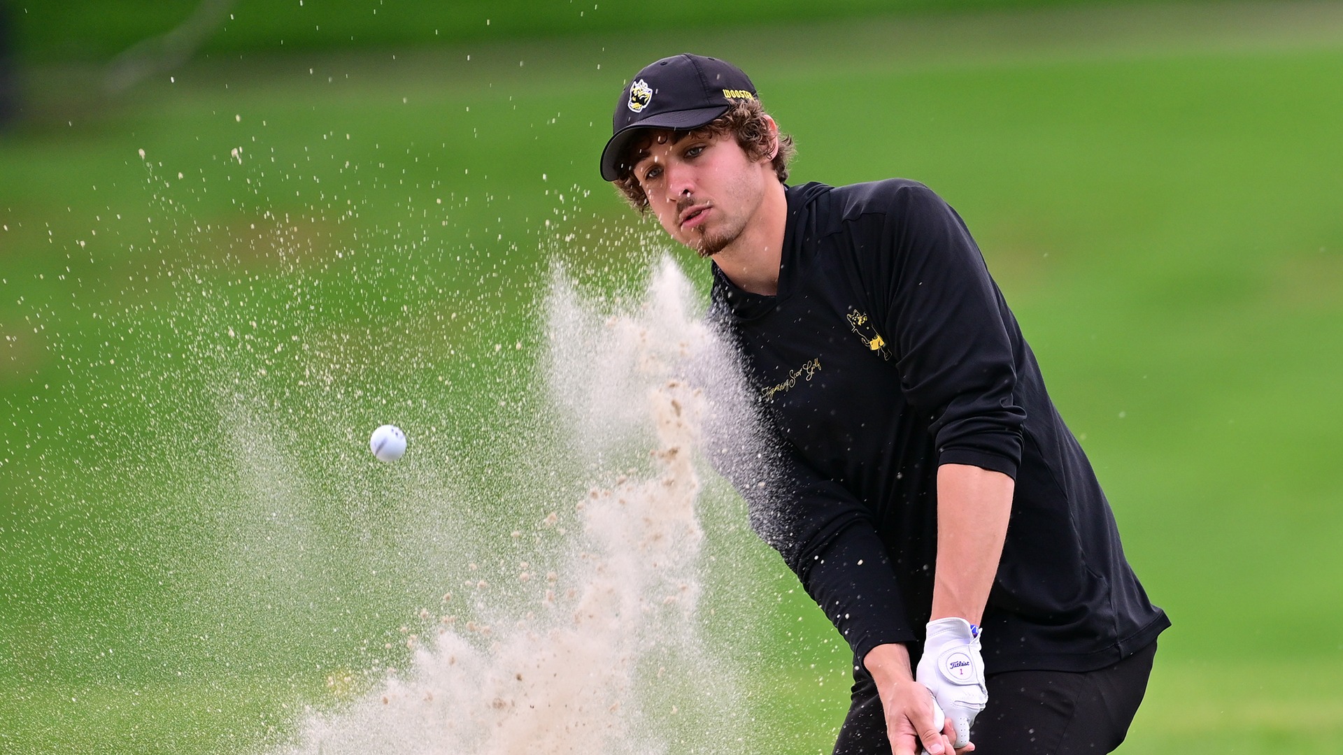 Mark Towns hits out of the No. 10 bunker at Wooster Country Club during the Nye Intercollegiate