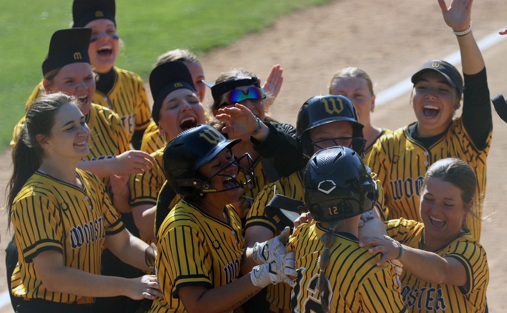 The softball team rushes Meszaros to celebrate her walk-off hit