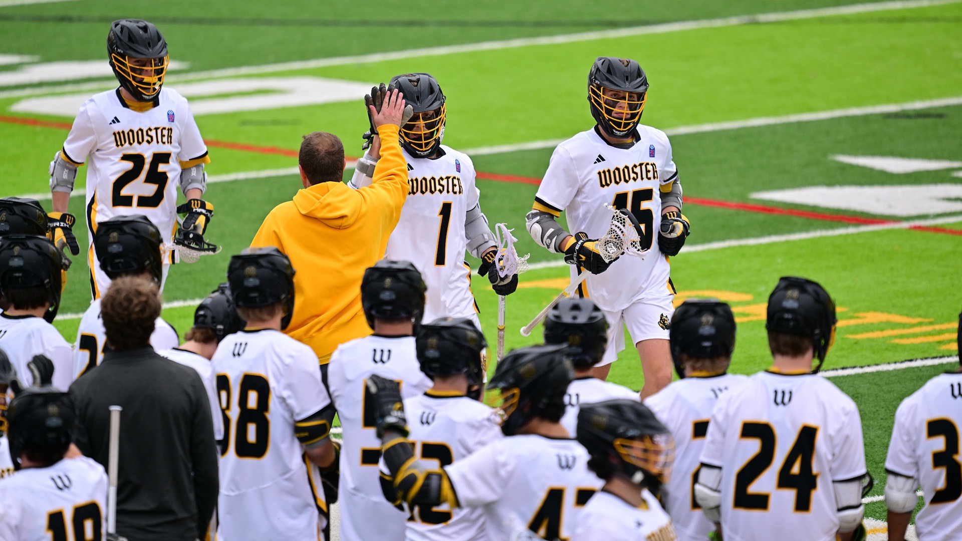 Ian Marsland gets a high-five returning to the Wooster sideline