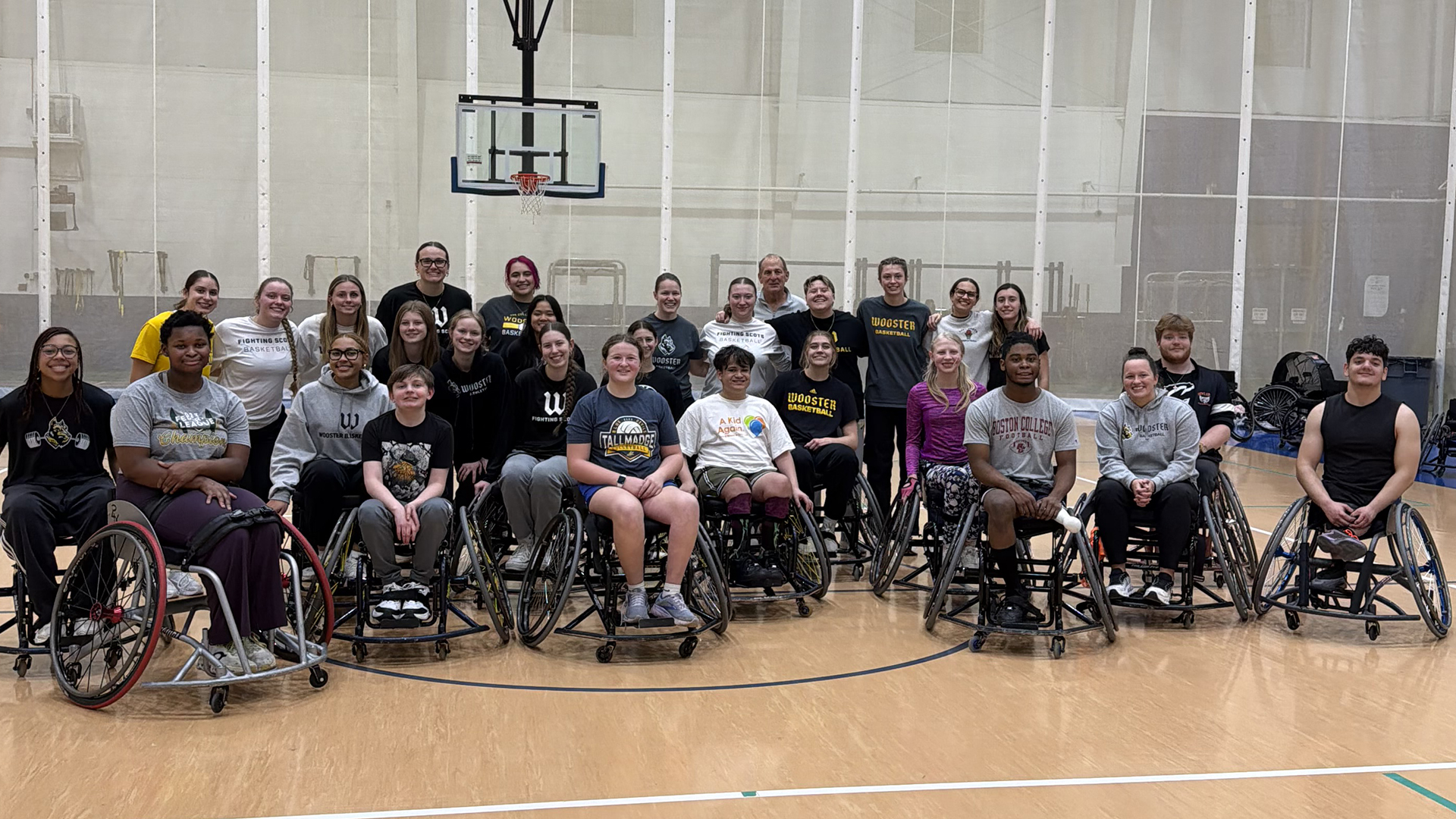 Group photo of Wooster women's basketball players with Adaptive Sports wheelchair basketball participants