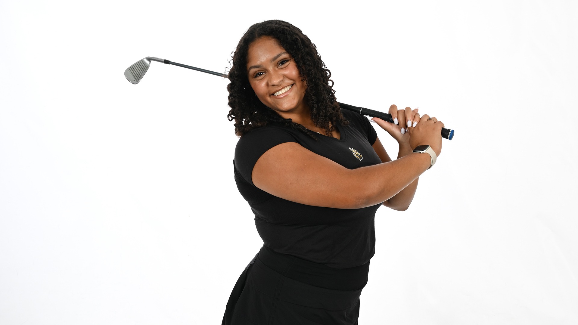 Alexis Neal smiles while posing with a club during 2025-26 media day