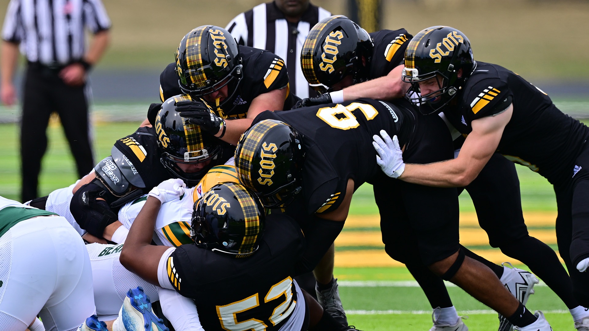 Donovon Jackson makes a tackle with the help of teammates in a 2025 game.