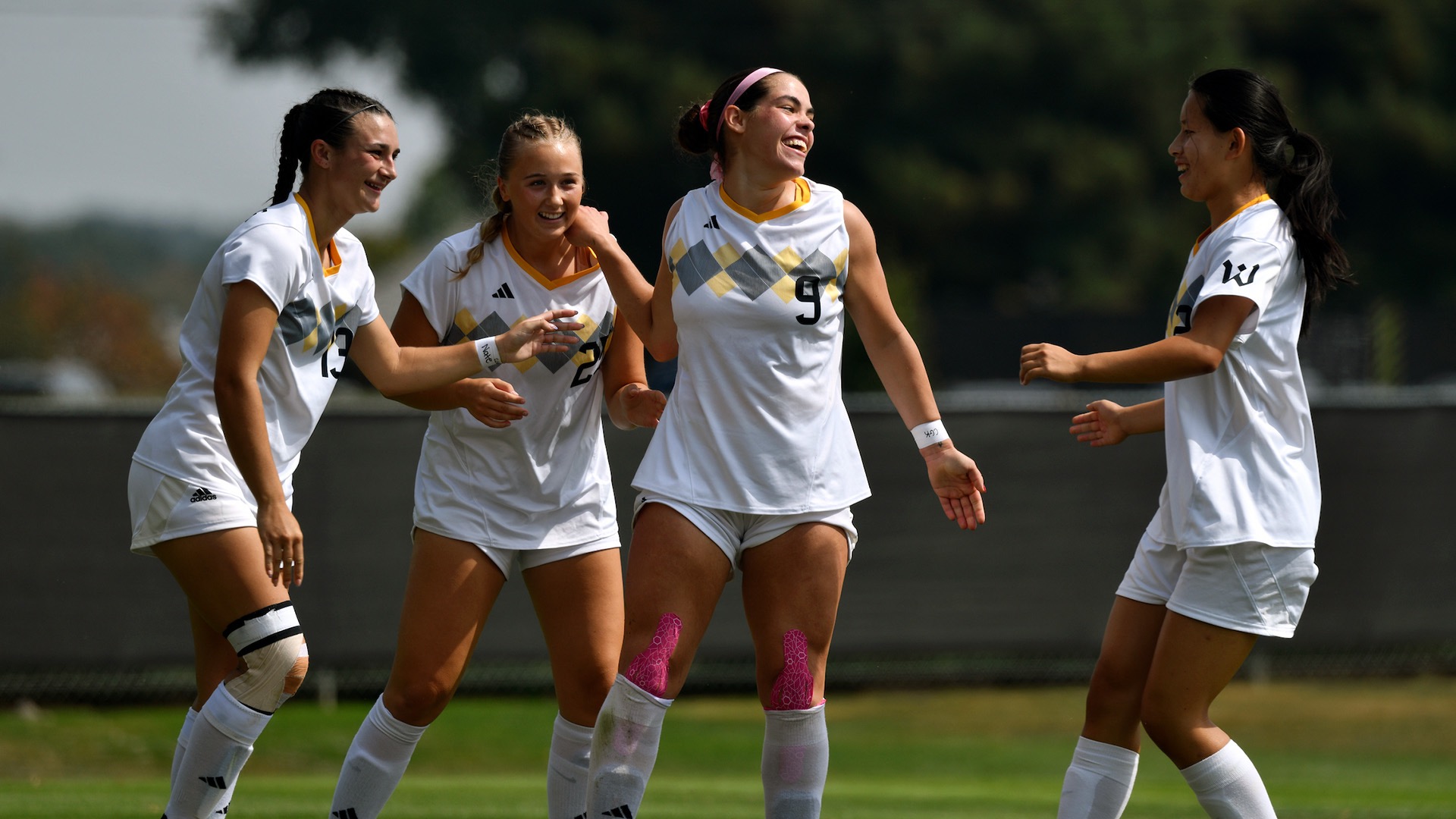 Members of then women's soccer team celebrate after a score