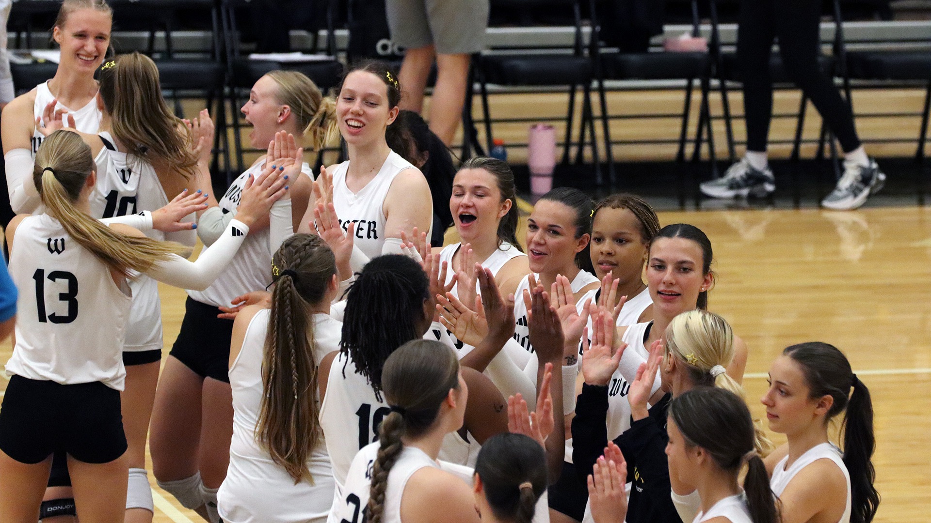 The volleyball forms a line to slap hands before their match