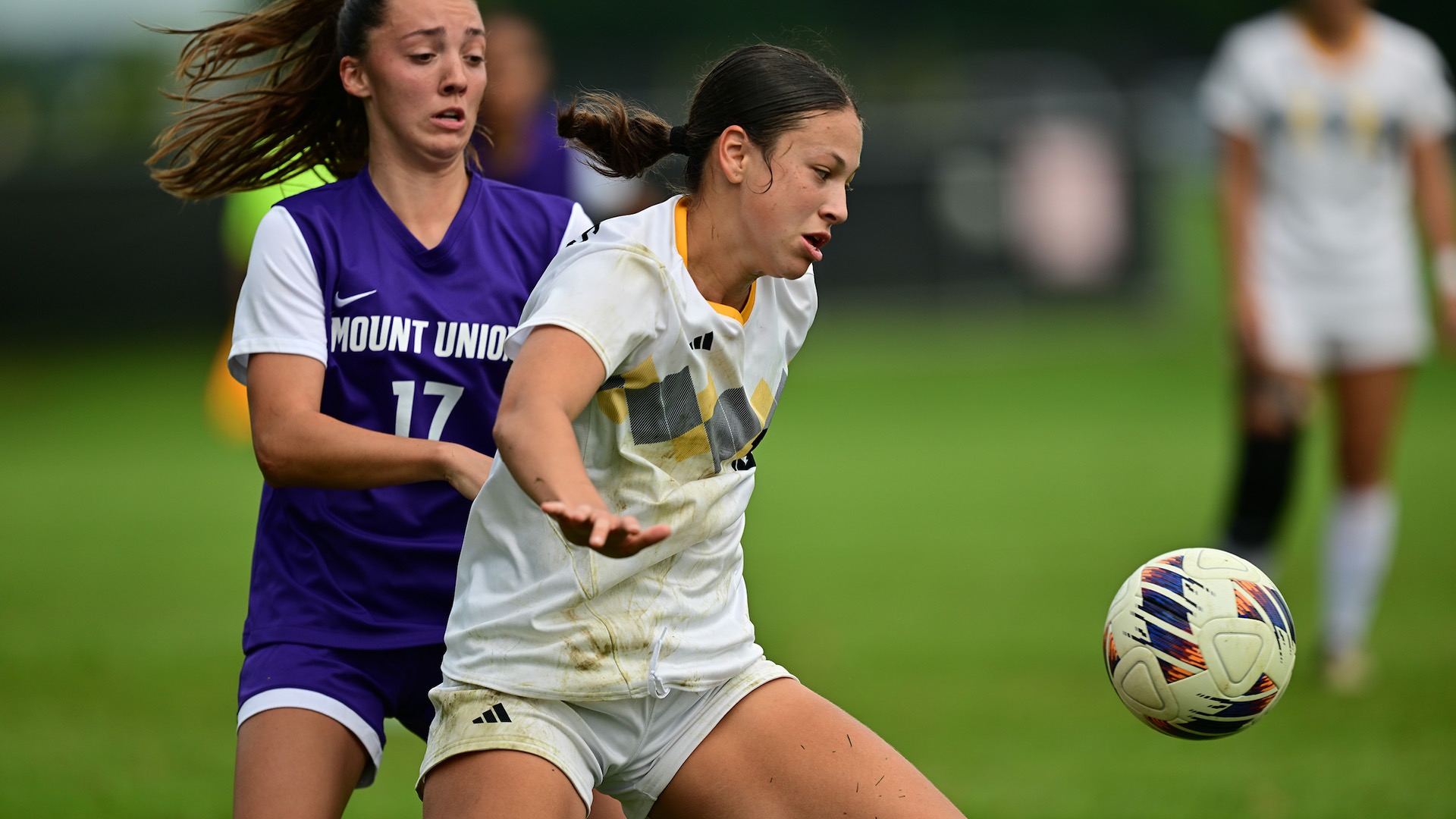 Bella Crompton battles for possession with a defender behind her