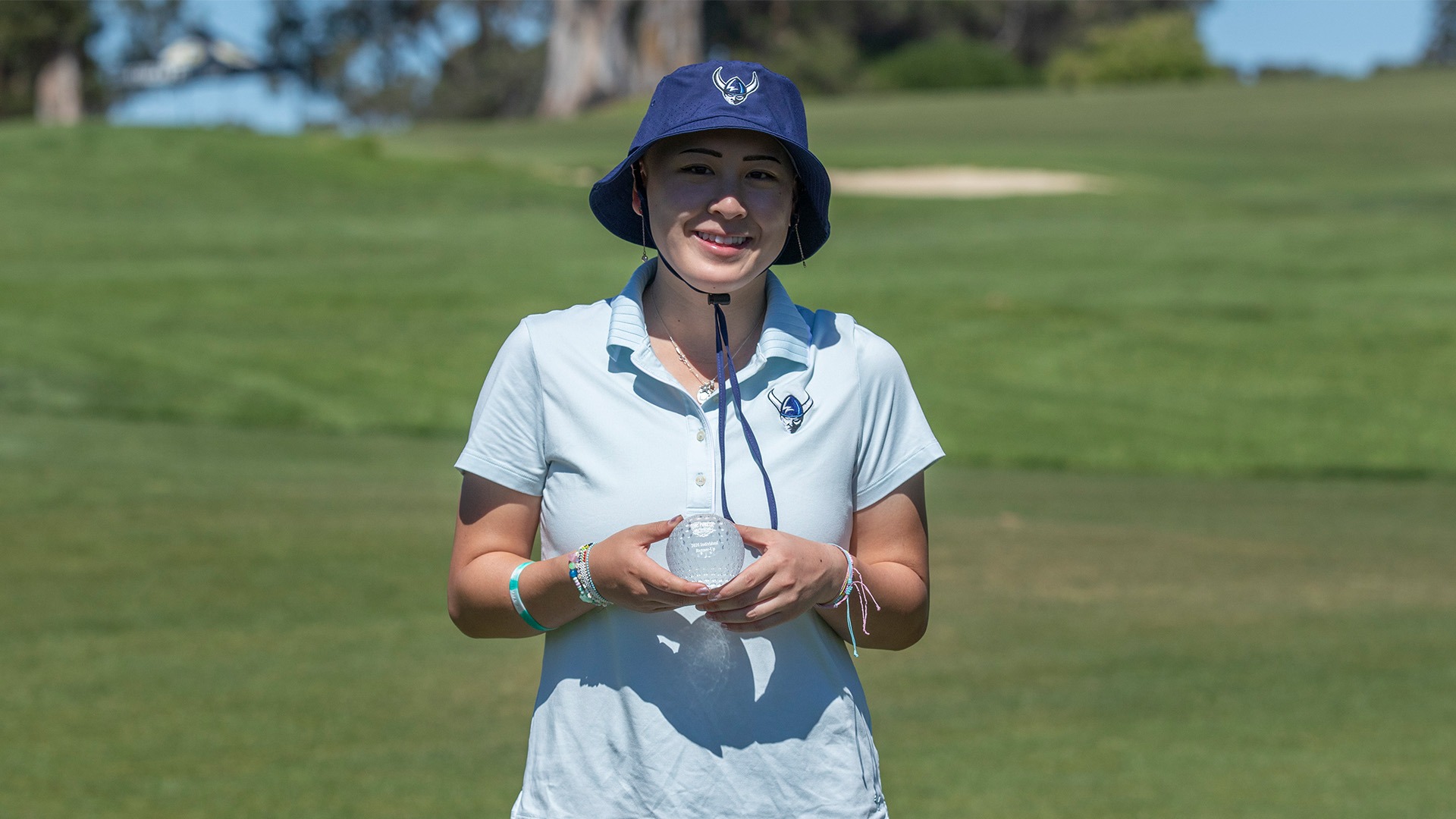 Lauren Lee Runner Up at The Big Freeze - Golfer holding a trophy with green grass in the background
