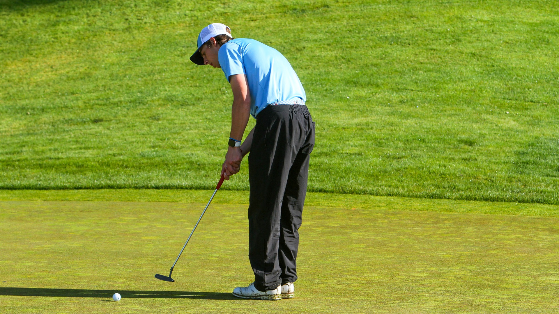 Nick Ennis at GNAC Championships | Golfer on a putting green making a putt