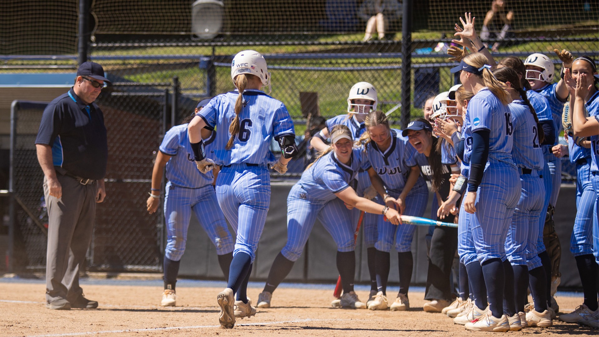Softball Recap vs. Saint Martin's | Laila Carpenter greeted at home plate after hitting a 2-run home run. Teammates are surrounding home plate waiting for her to arrive.